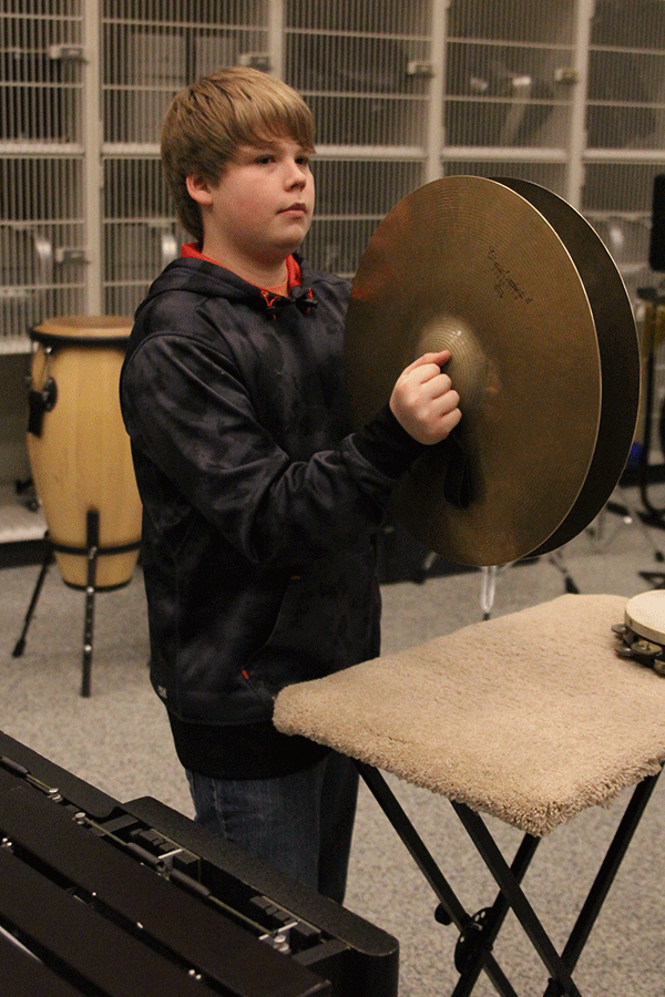 Sophomore Alex Sambevski prepares to play the cymbals during a timeout at the boys basketball game on Thursday, March 5.