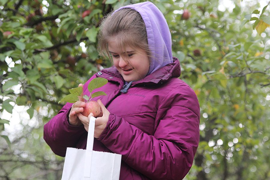 Admiring her apple, junior Maria McElwee prepares to put the fruit into her bag.