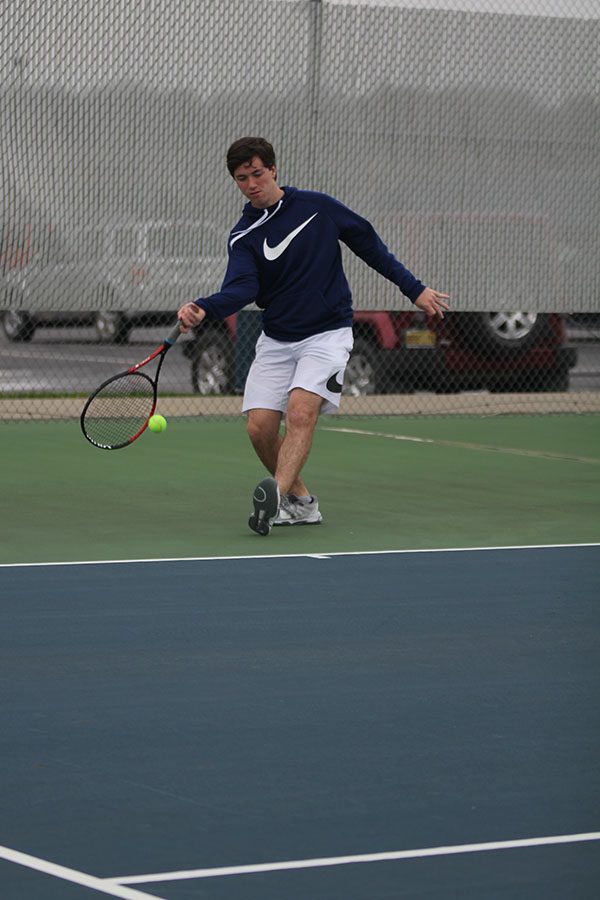 Following through with his racket, junior Joey Gillette underhands the pass.