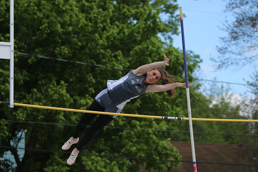 Competing in the pole vault event, senior Abby Phillips propels her body over the pole.