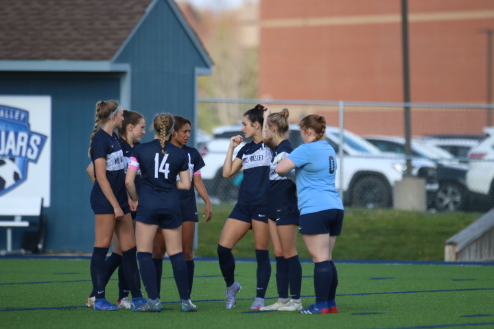 The varsity soccer team huddles up before the start of the game