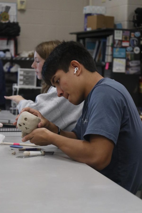 Junior Walt Midyett carves a face into his clay pumpkin project Monday,Sept. 19 in Erica Matyak’s Ceramics I class.