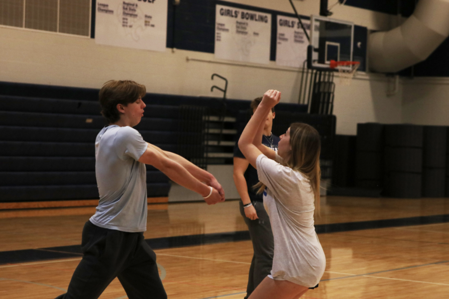 Juniors Katelyn Andrews and Adam Seymour both go for the ball to hit a serve.