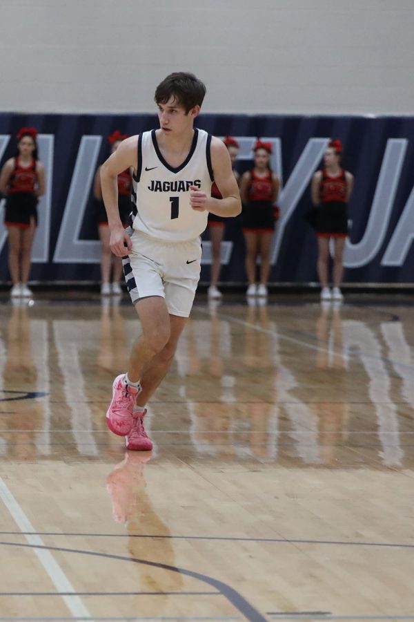 Running down the court, senior Brooks Jahnke gets ready for the next play. 