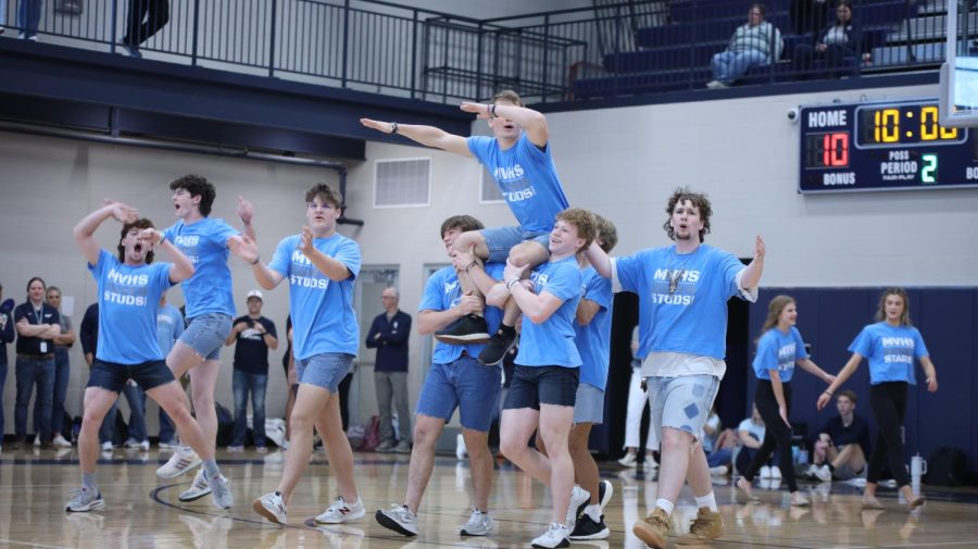 Being carried by his friends, senior Hayes Miller dabs while walking out during the Silver Studs performance.  
