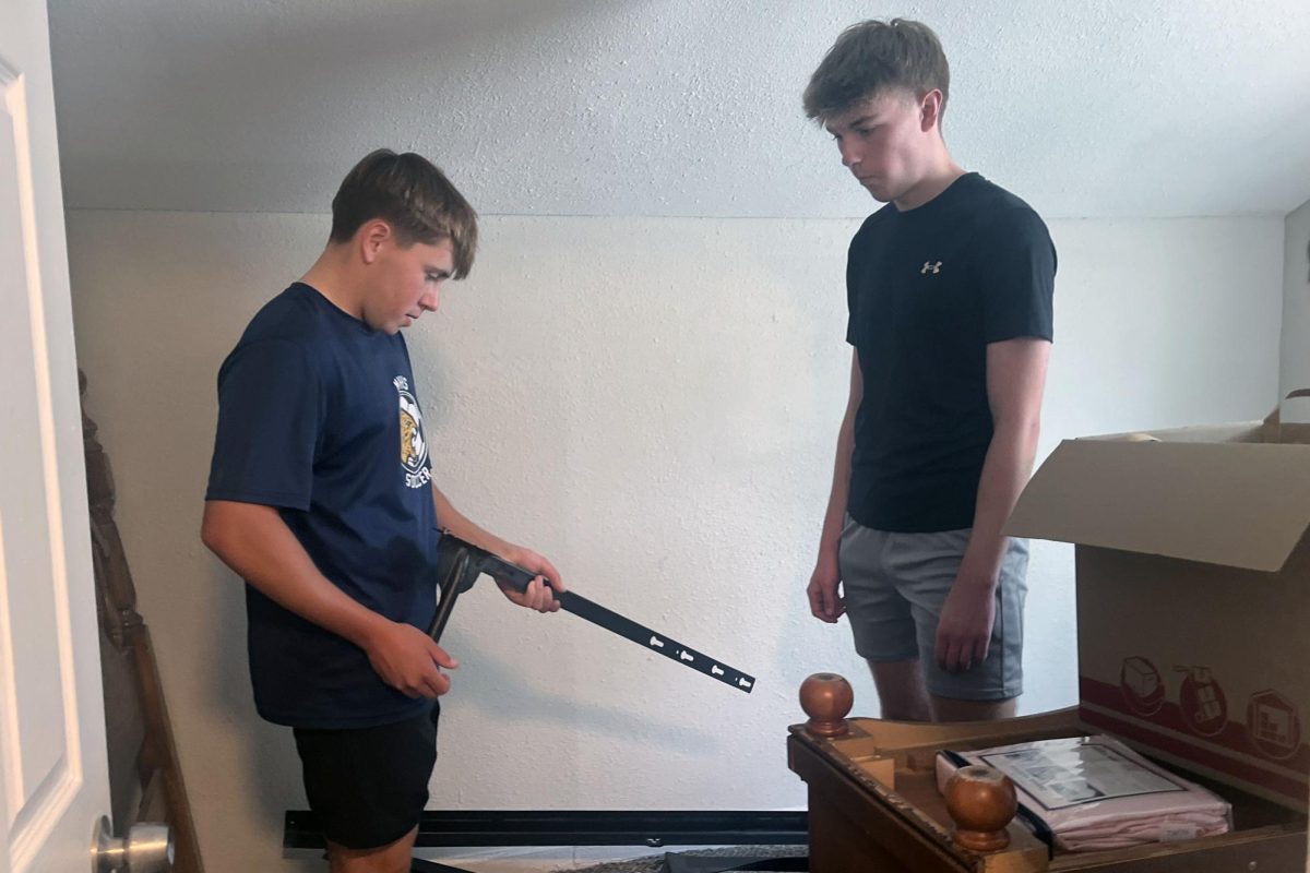 National Honor Society members juniors Carter Coup and Drew Enloe work together to figure out the construction of a bed frame.