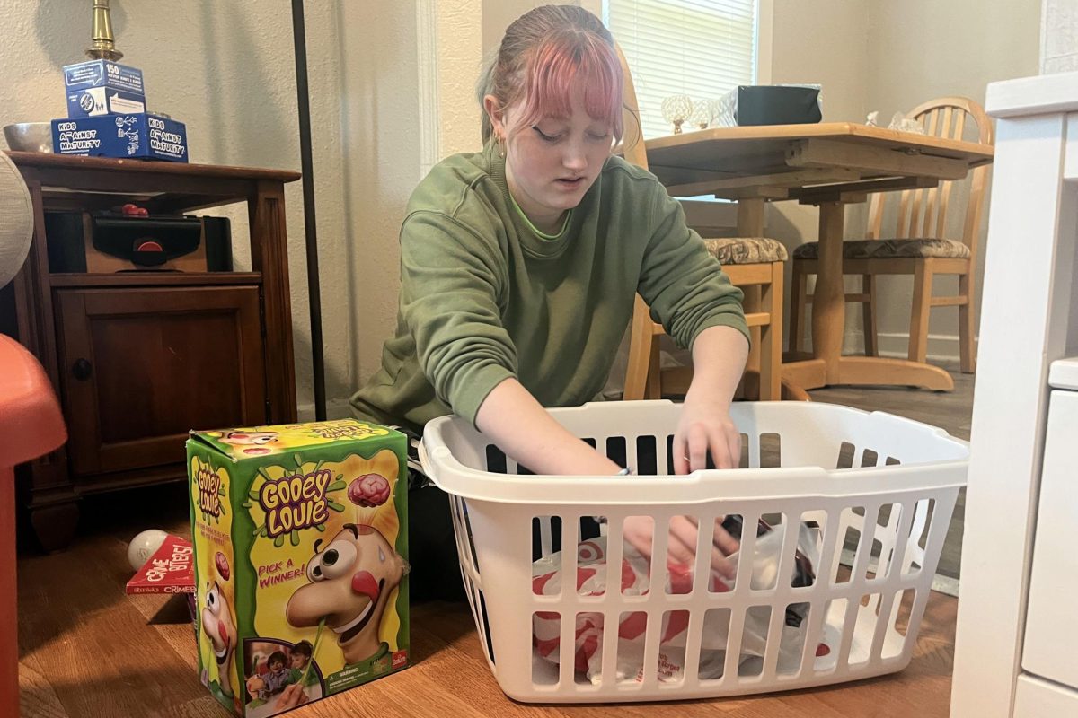 Youth for Refugees co-president senior Emma Clement unpacks a box of toys for the refugee children.