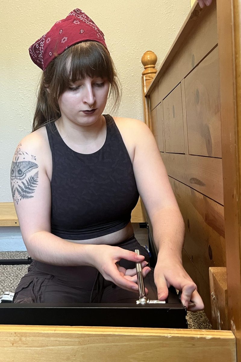 Youth for Refugees co-president senior Anna Zwahlen tightens a screw in the bed frame she has constructed.