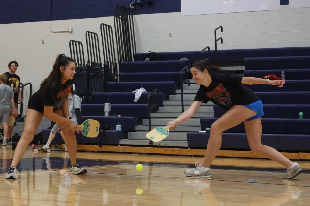 Sophomores Stella Beins and Paige Roth lunge for the ball to save it from hitting the ground. 