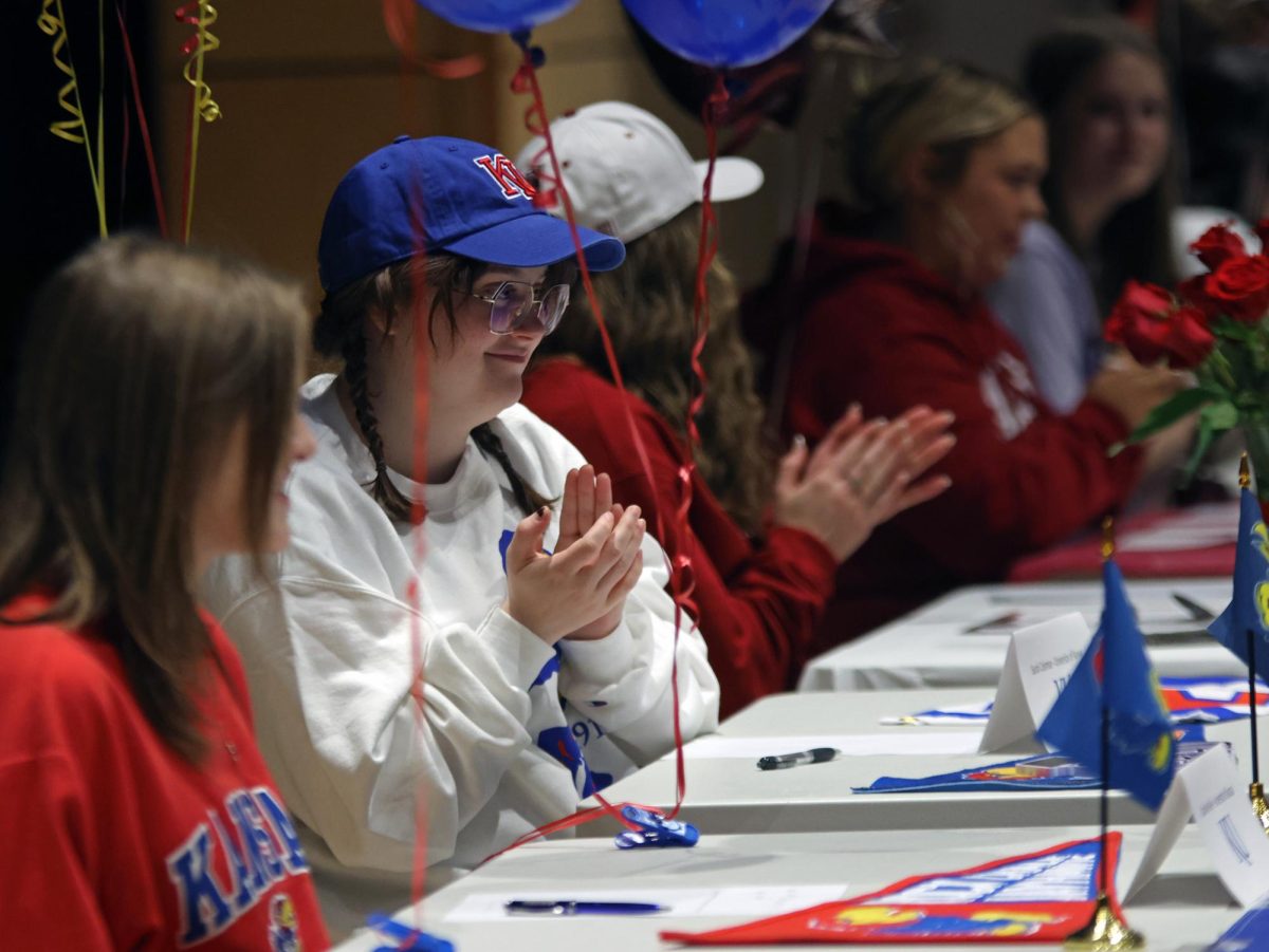 Senior Sarah Coleman claps for her peers that are also signing. 