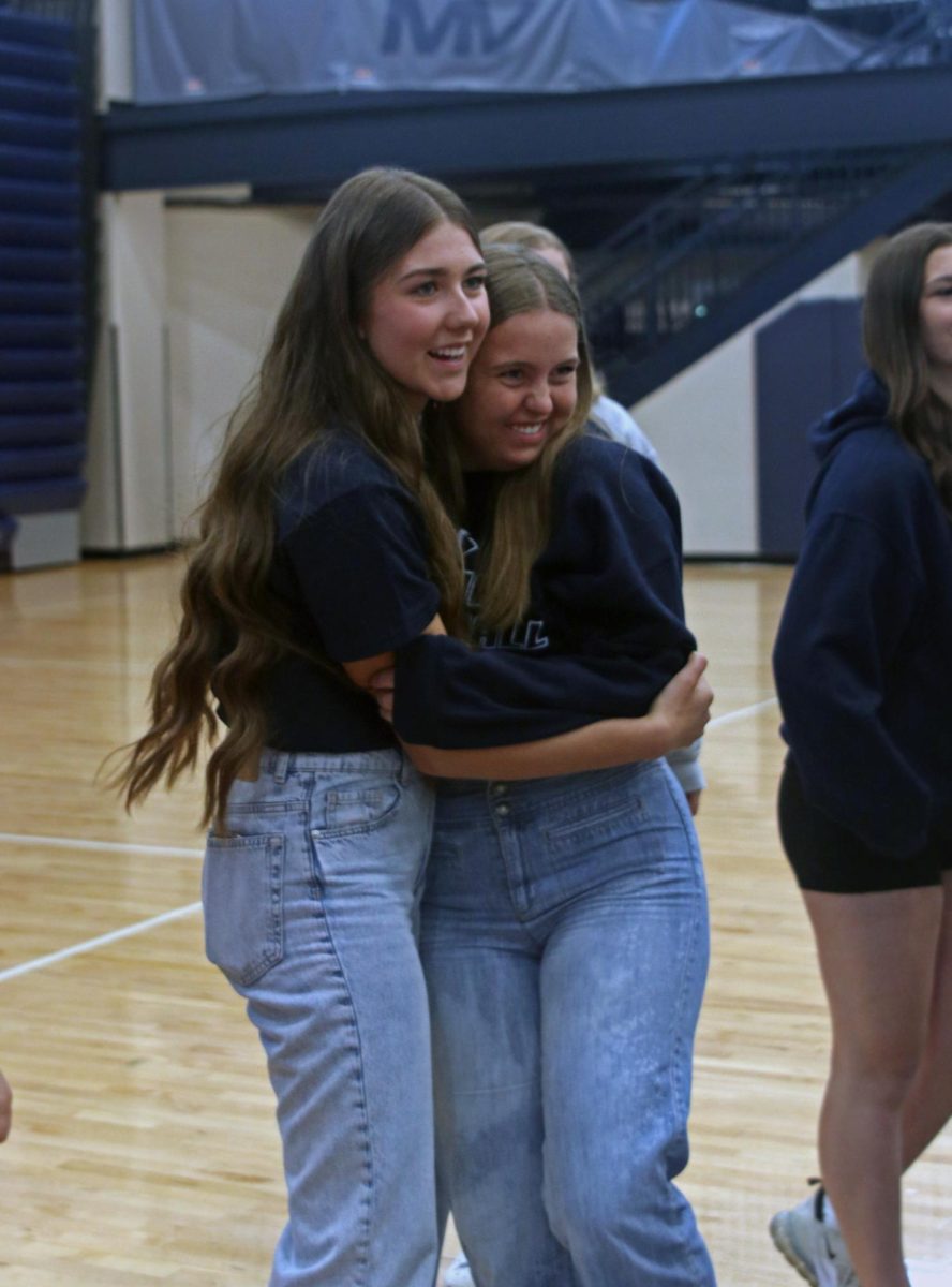 Seniors Brooklyn LaFon and Elly Vanrheen hug after the signing ceremony. 