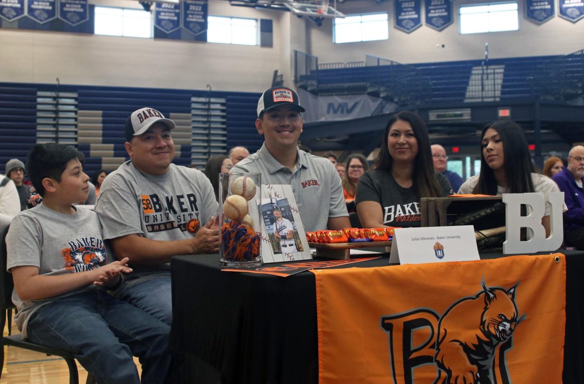 Signee senior Julian Meneses signs for Baker University baseball while surrounded with his family. 