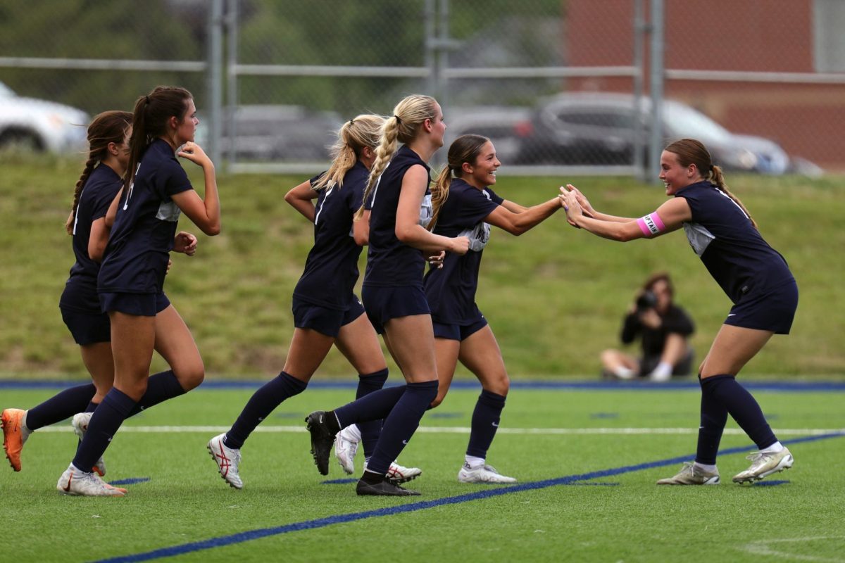 After scoring a goal, freshman Paige Frost high-fives senior Kate Ricker.