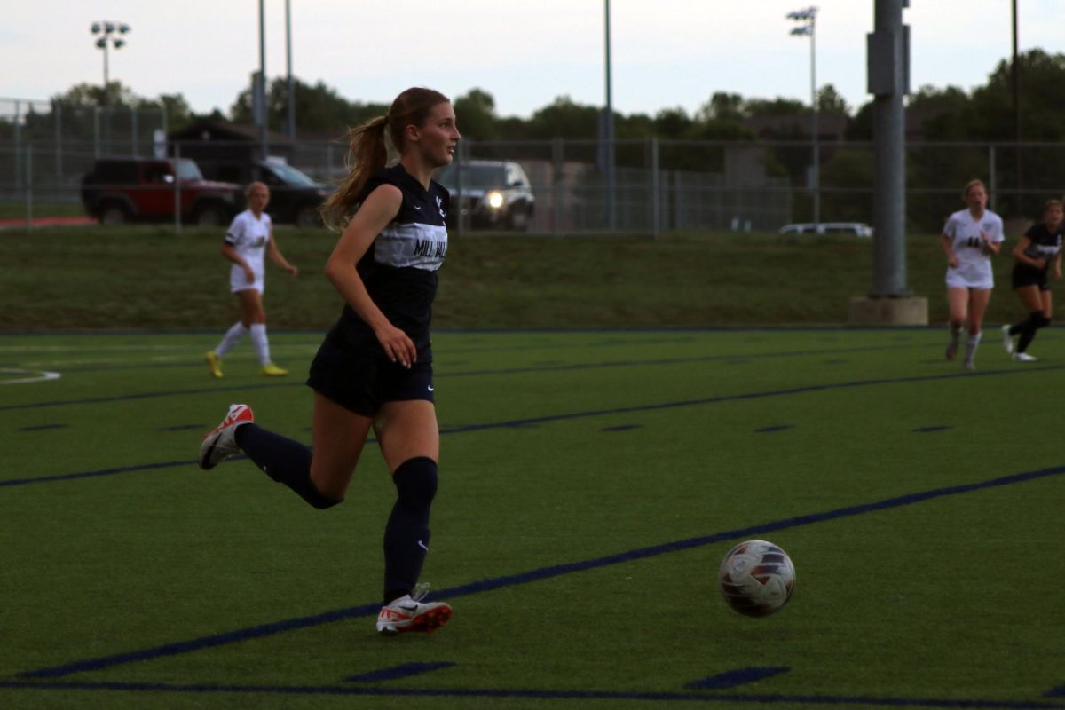 Running with the ball, Junior Kate Martin runs to avoid opponents 