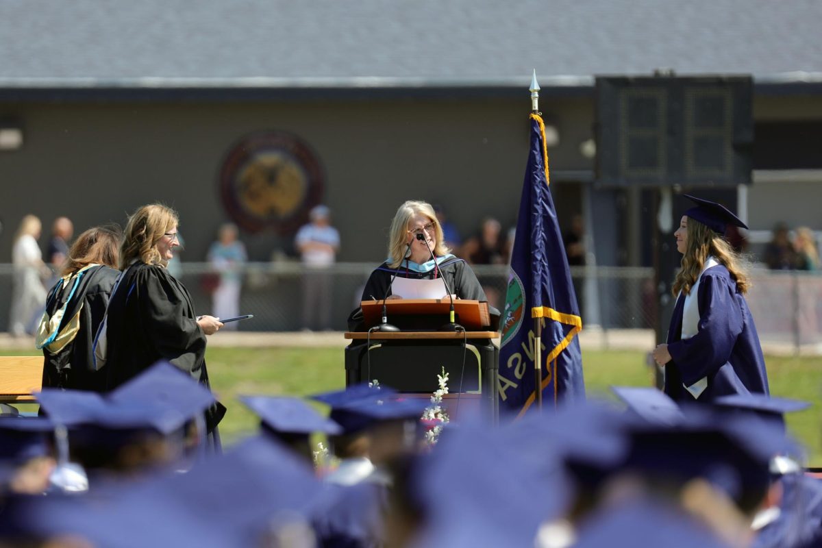 After hearing her name called, graduate Reagan Enemark walks across stage.
