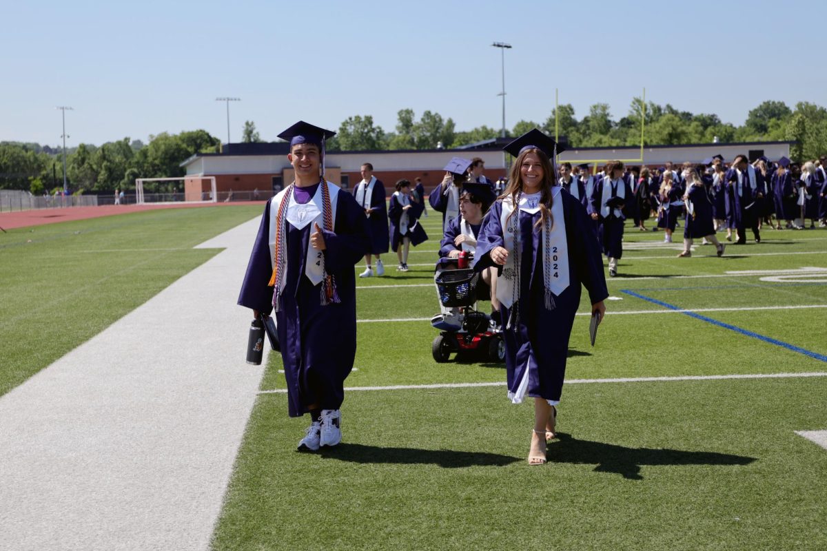 Smiling, graduates Lucy Roy and Walt Midyett walk the class out of the ceremony.