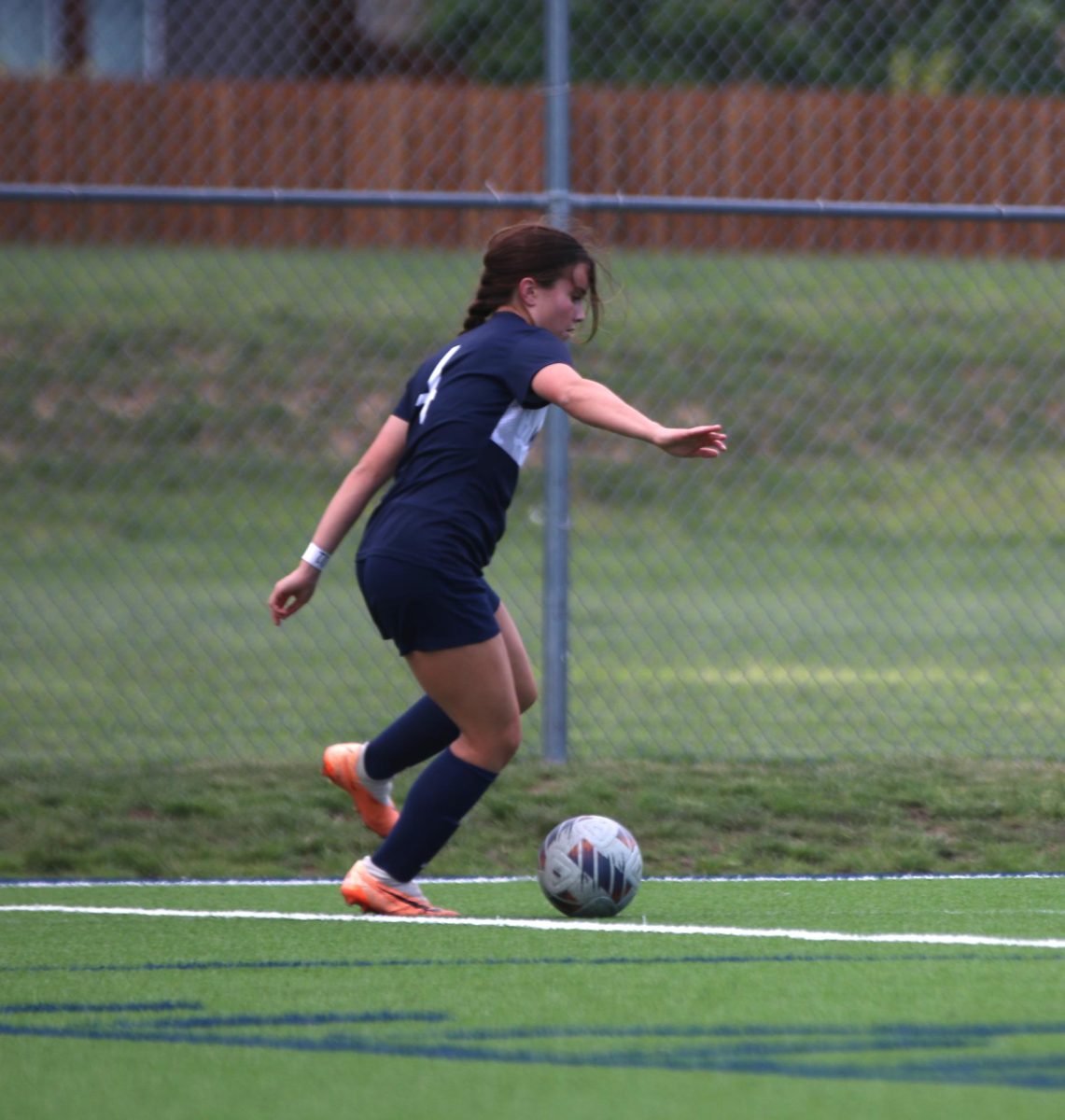 Preparing to kick the ball, junior Lauren Welch looks out into the field for an open teammate.