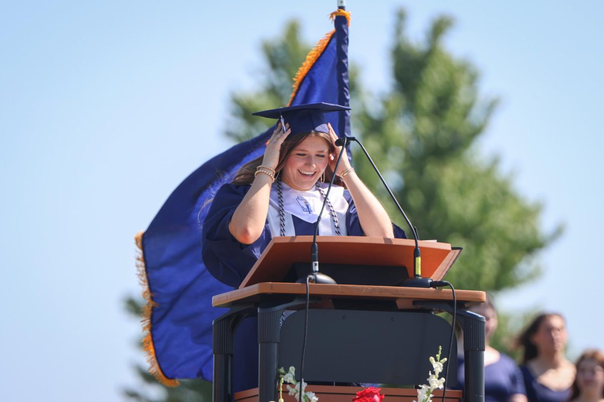 Holding her cap, senior Lucy Roy gives her speech during graduation.  