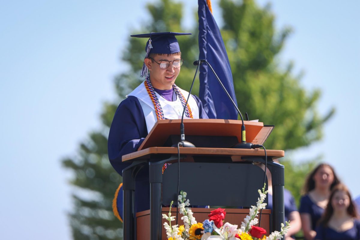 Looking down at his papers, senior Walt Midyett gives his graduation speech.