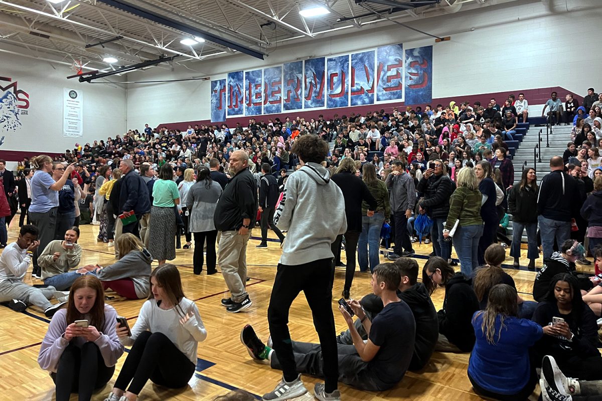 Sitting on the MTMS gym floor, groups of students talk with their friends while waiting for updates Thursday, March 7 2024. 