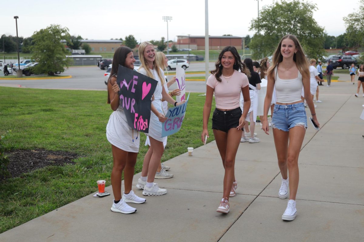 Two incoming freshman girls smile as they walk through the crowd of students welcoming them to the Valley.