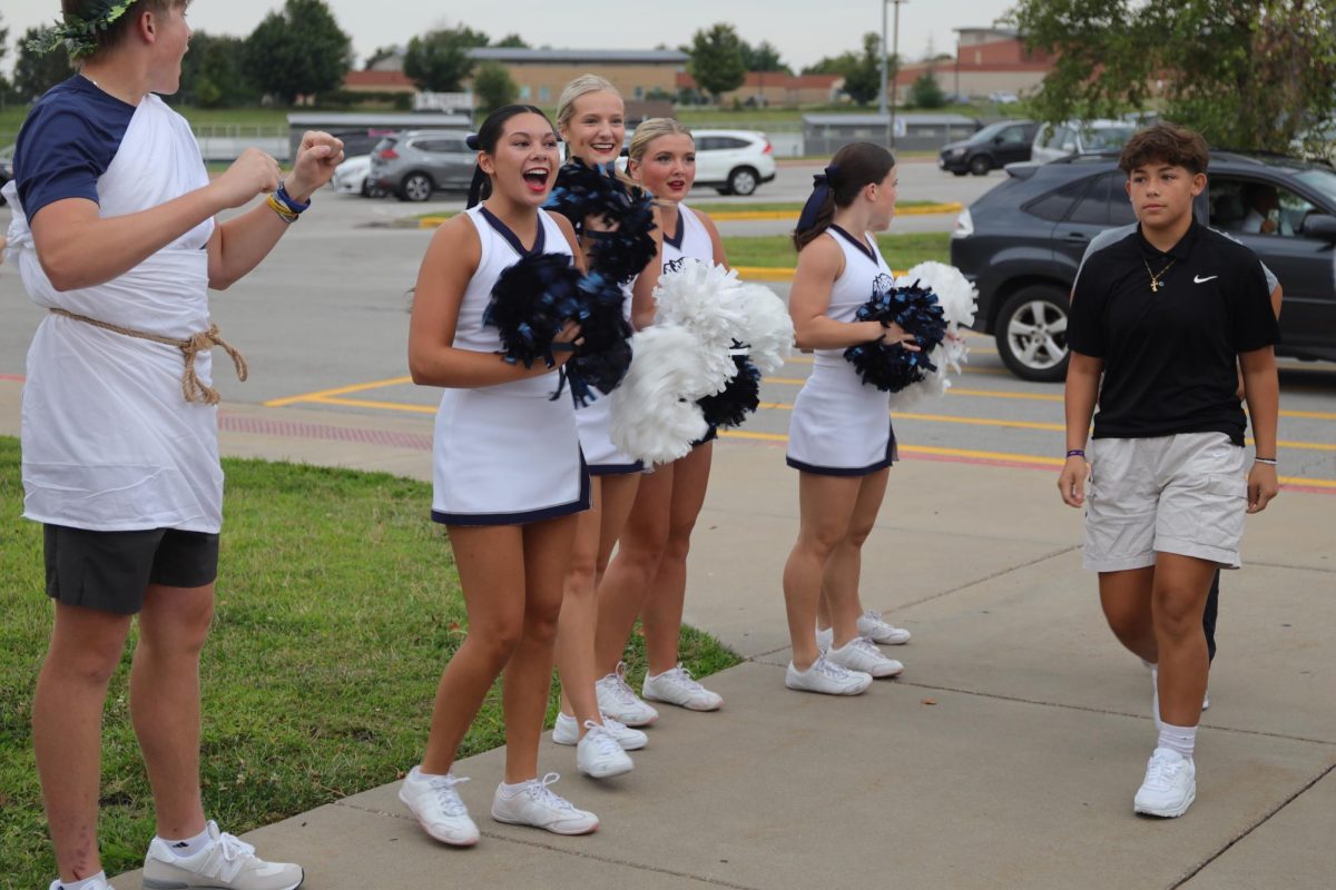 Junior Stella Beins cheers as the freshman enter the building.