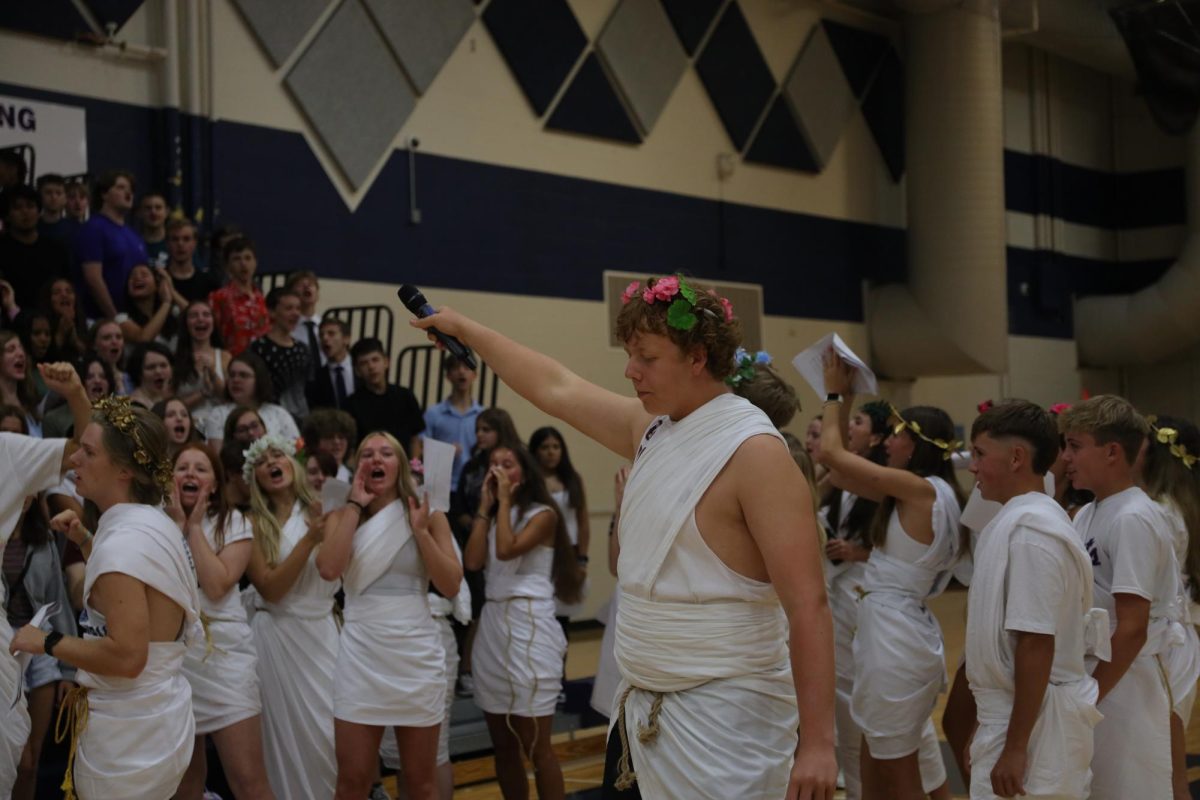 Holding the mic up to the freshmen, senior Aiden Lehr leads a chant.