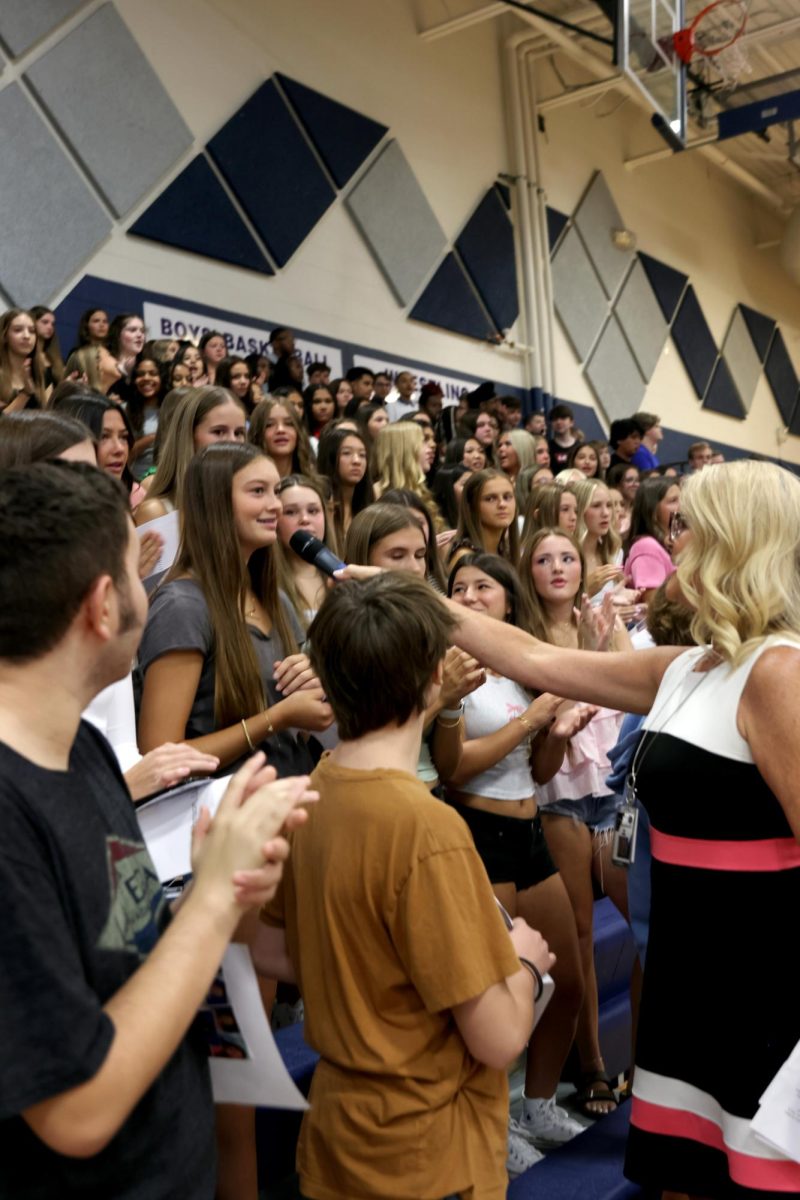 Holding the mic to an incoming freshman, principal Dr. Gail Holder gets the freshmen class engaged in the fight song.