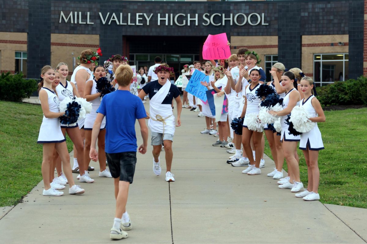 Excitingly, junior Gavin Hurt welcomes a freshman through the crowd of students.