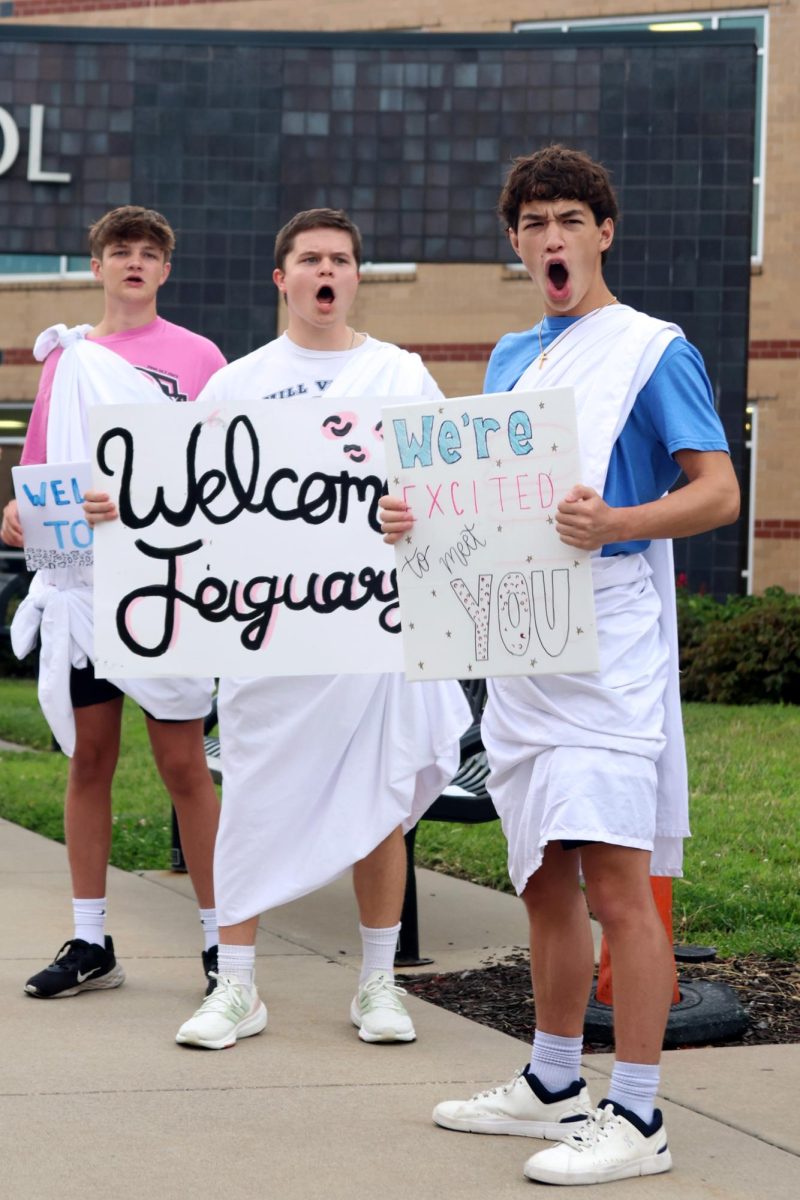 Cheering for the freshman, seniors Noah Pham, Matthew Tieman and Blake Rieke hold signs.