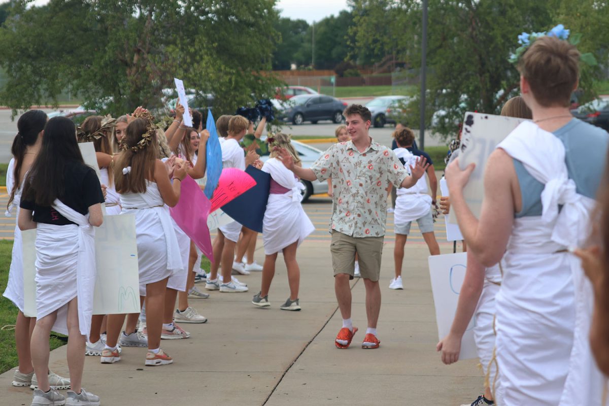 Greeting the crowd, a freshman prepares to enter the school. 