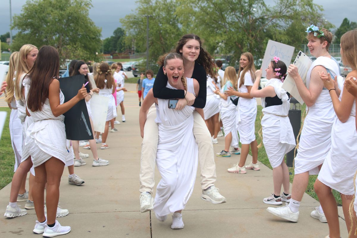 Giving a piggyback ride, senior Juliya Laws carries freshman Kathryn Laws into the building.