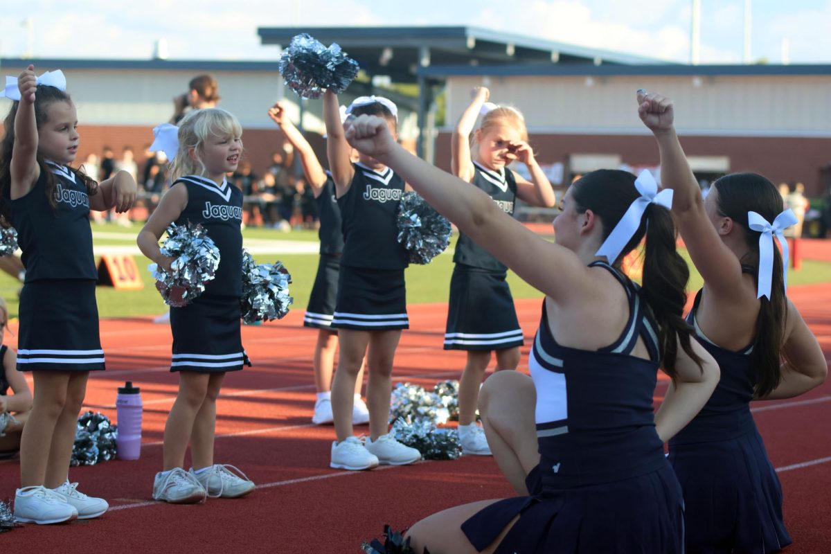 High school cheerleaders lead their group of Junior Jag cheerleaders in a chant.