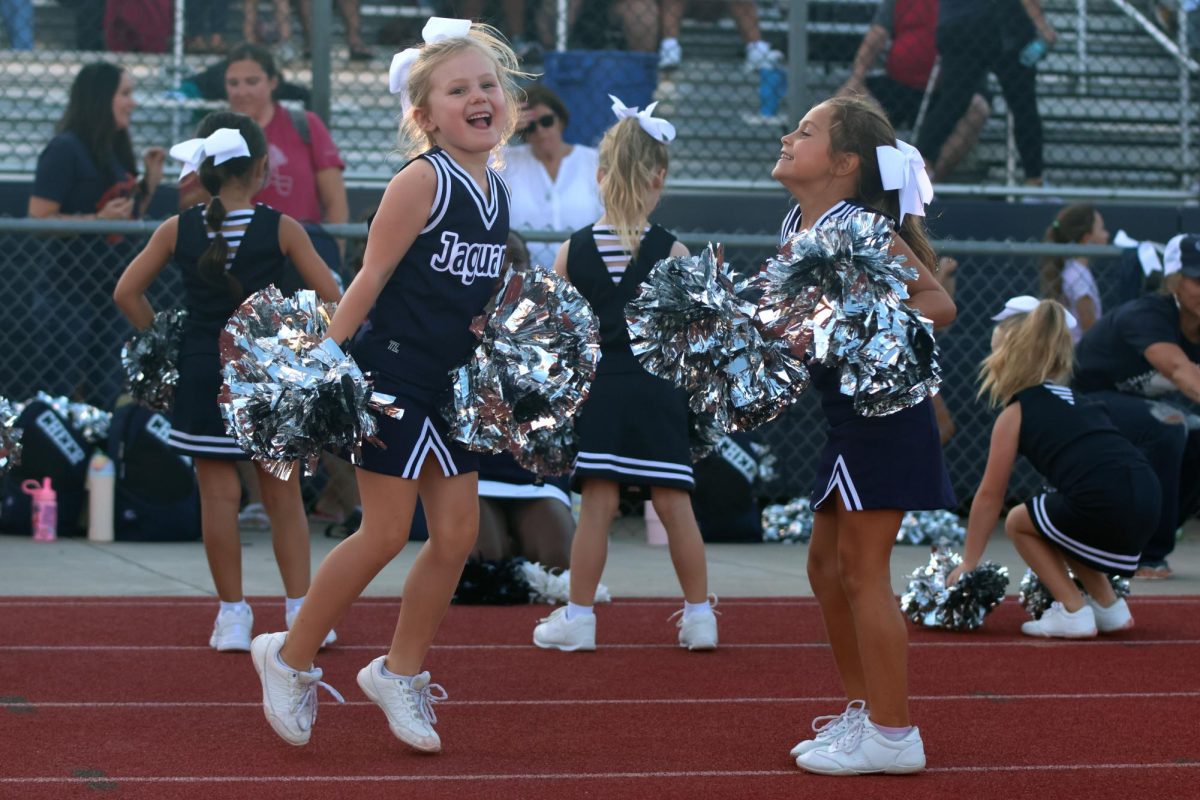 Junior Jag cheerleaders laugh as they practice their cheers. 