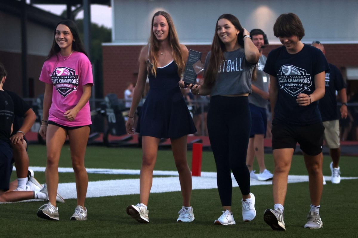 Seniors Avery Cole, Callie Cahoy, Molly Griffin and Thomas Helm walk across the field being recognized for the 2024 State Championship.