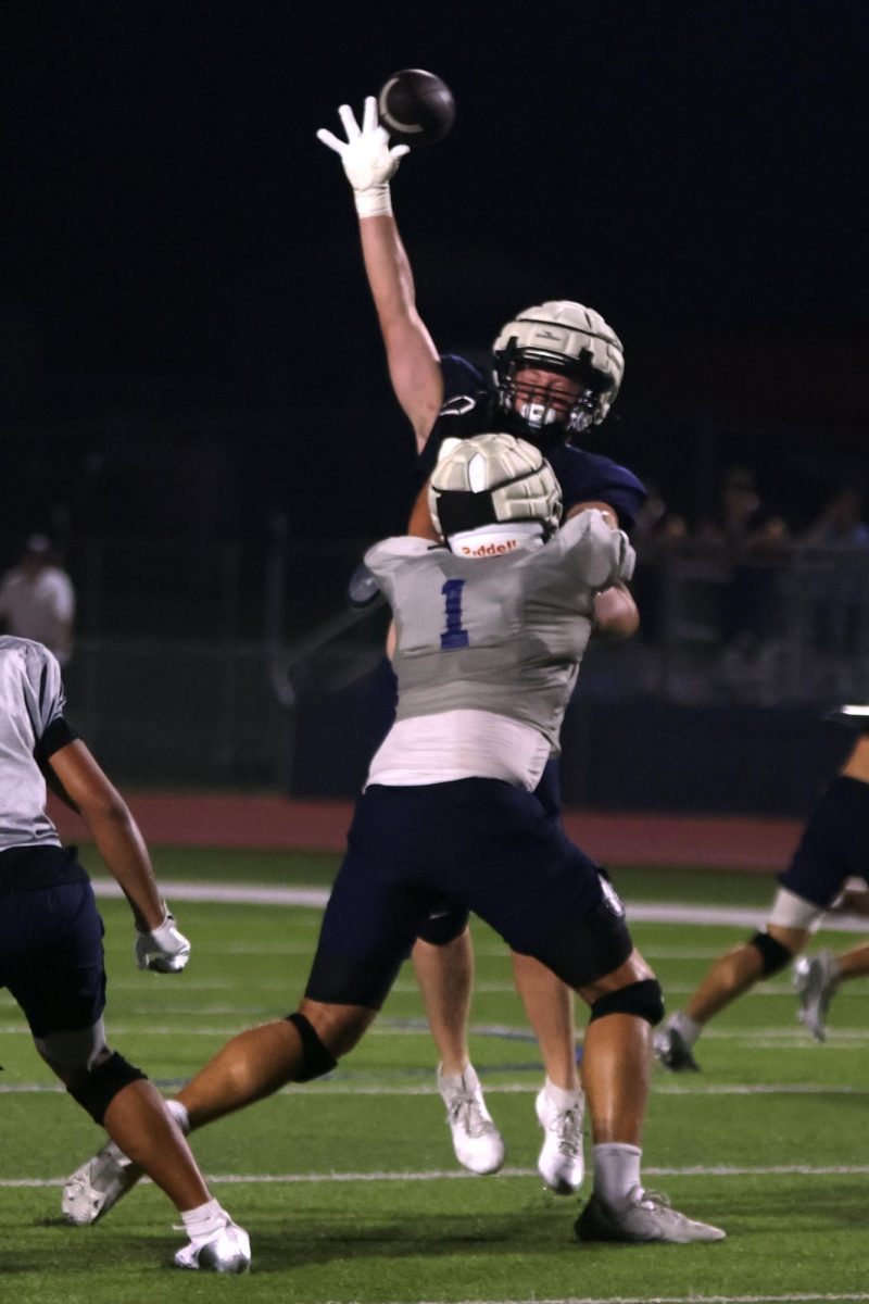 High school team member attempts to intercept the ball.