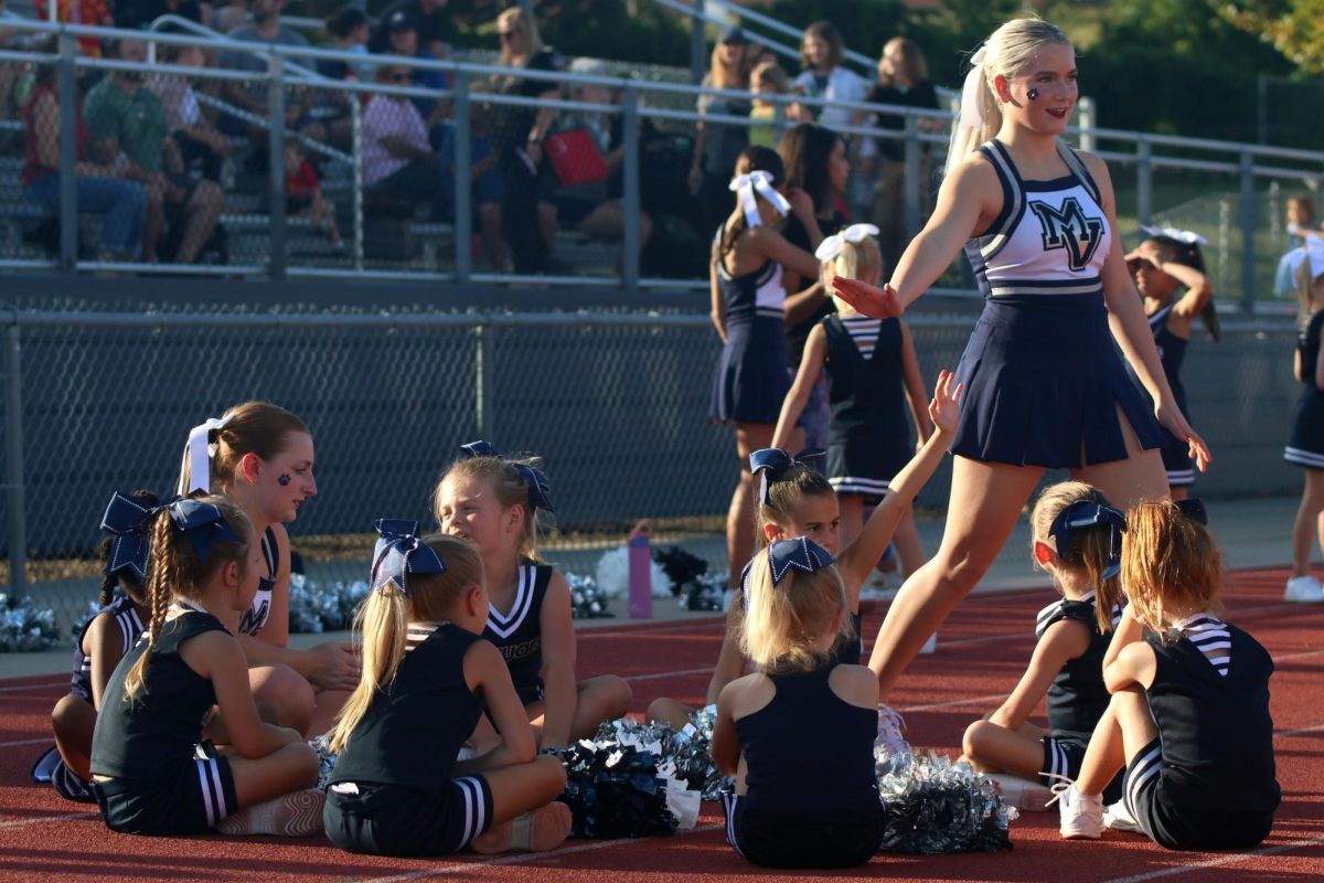 Sophomore cheerleader Olivia Pierce plays a game with her Junior Jag cheerleaders as they wait to do their cheers.