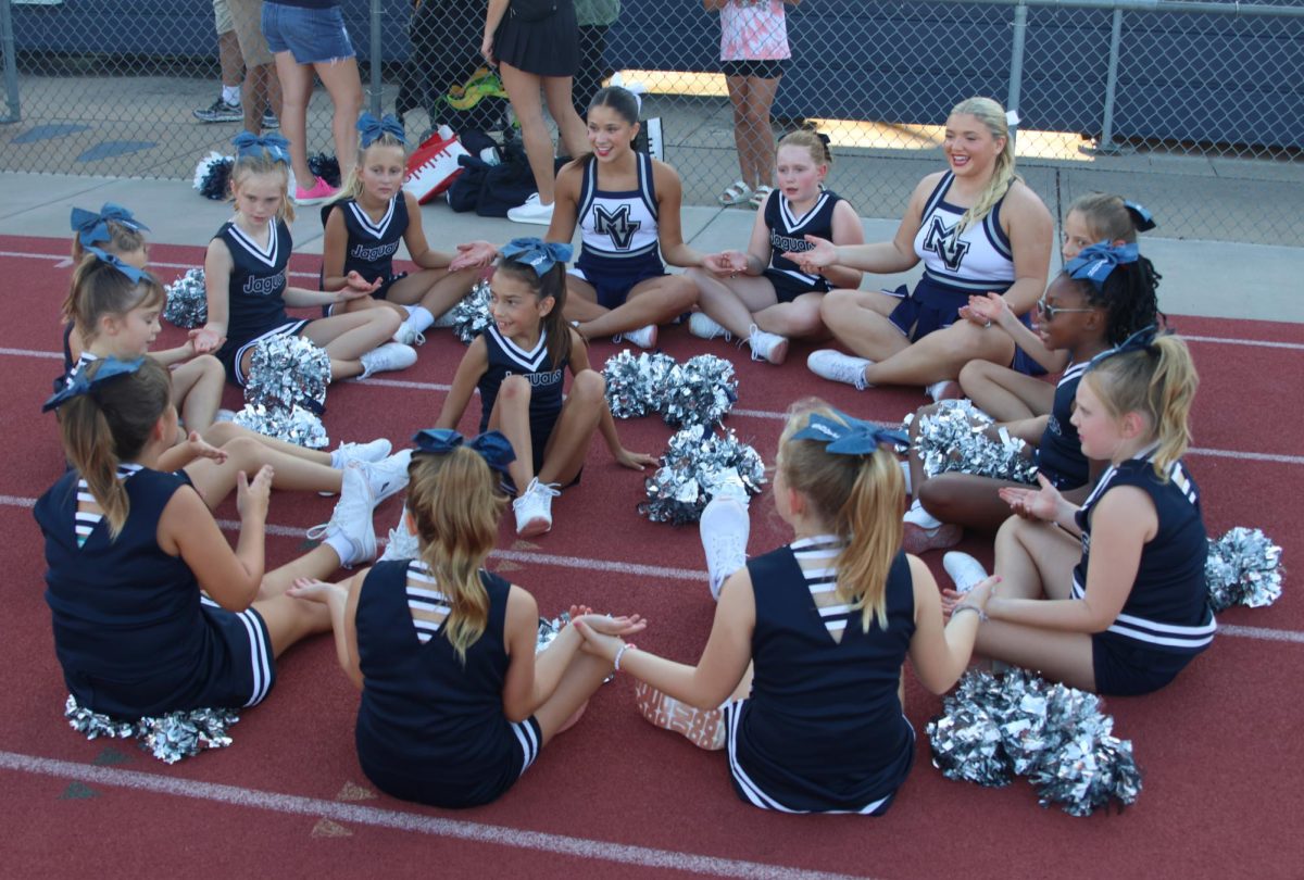 Seniors Emersyn Jones and Maddie Dibble play "Down by the Banks" with the Junior Jag Cheerleaders in between performances. 