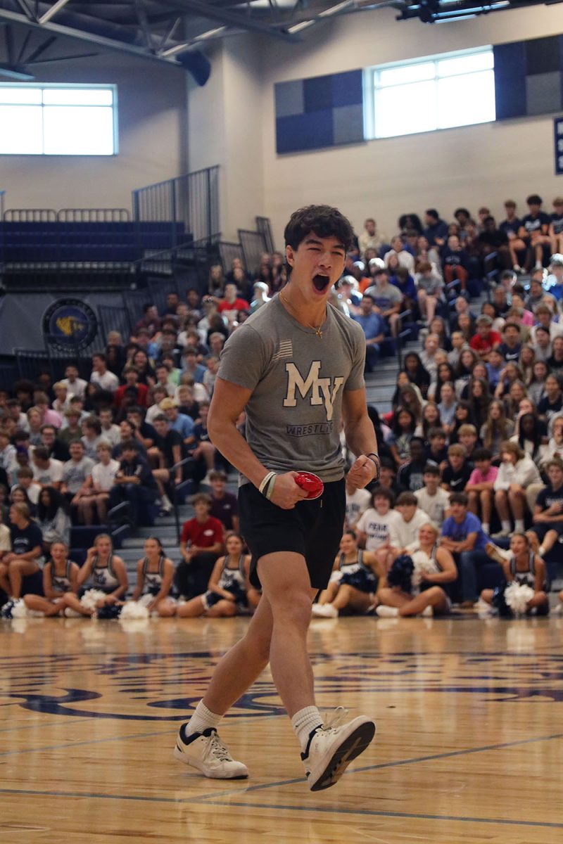 Facing the audience, senior Noah Pham celebrates after winning the assembly game.