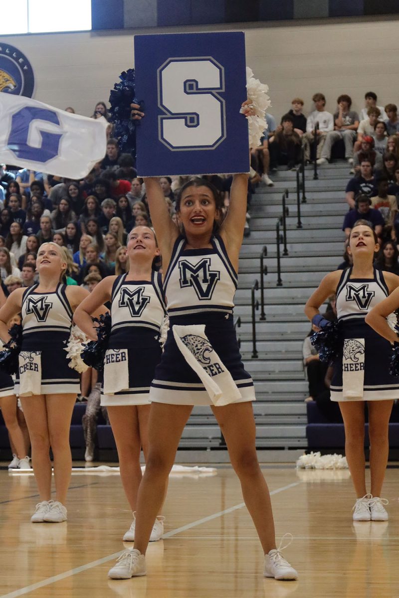 Holding the “S” sign, senior Jada Winfrey performs during the assembly with the cheer team.