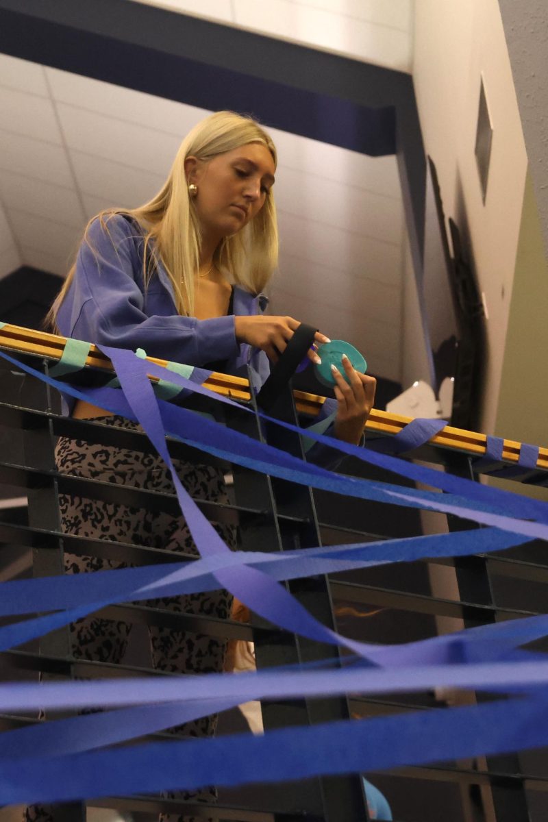 Holding streamers, senior Chloe Lancaster garnishes the railing. 
