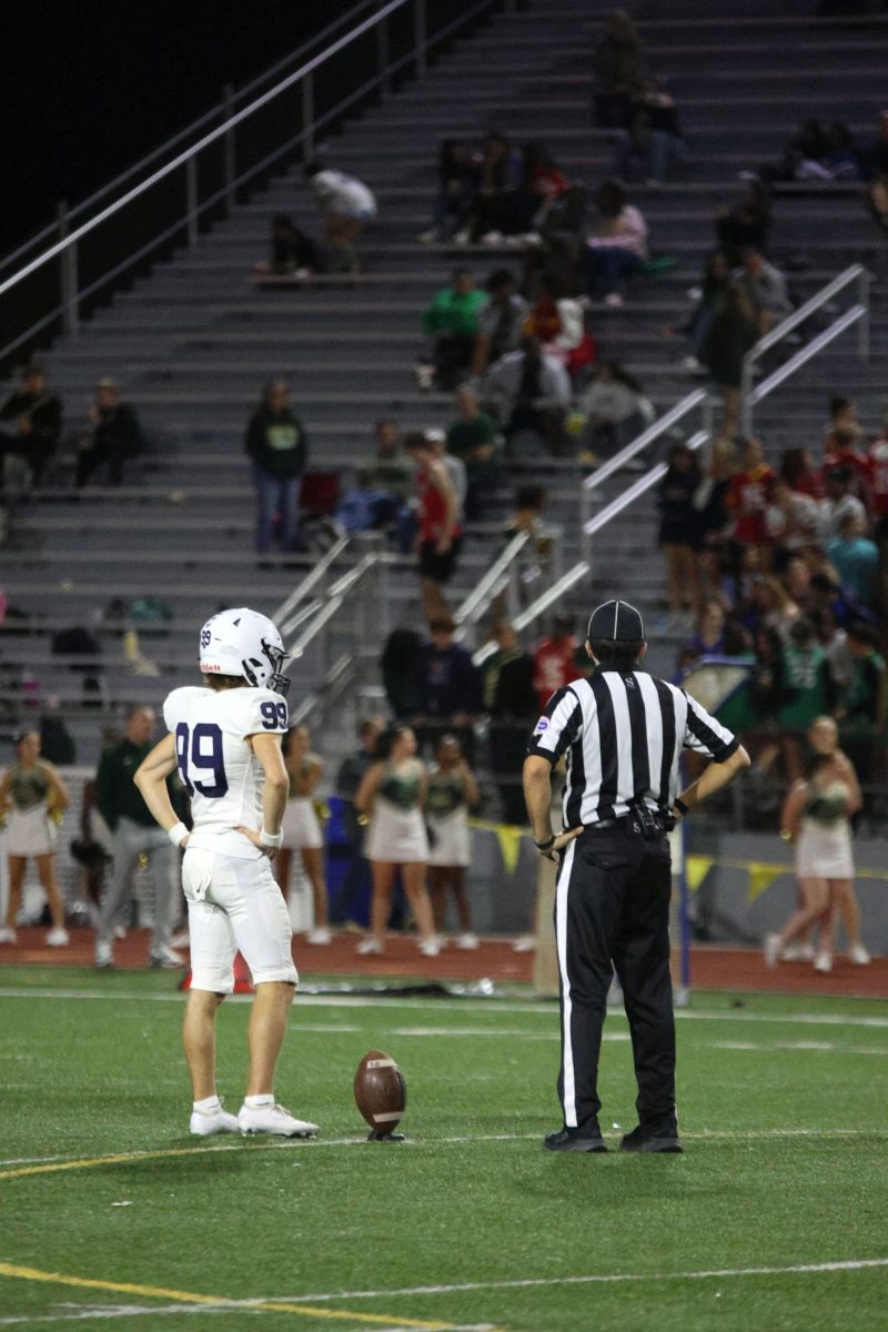 Standing with the ref, senior Aiden Standley waits for the next play.