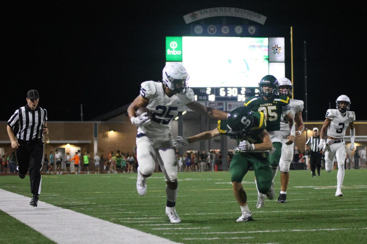 Going in for a touchdown, junior Reggie Reece blocks his opponent.