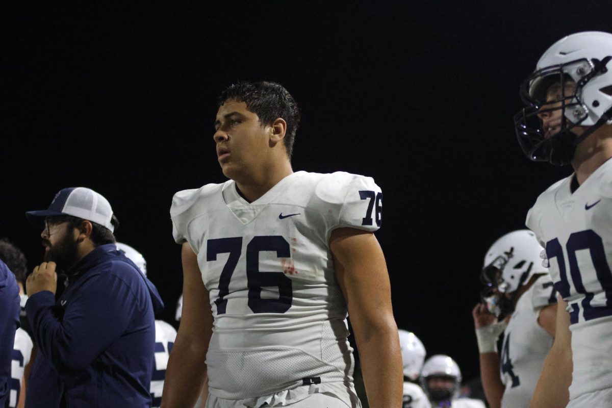 On the sideline, Senior CJ Tilley watches his teammates.