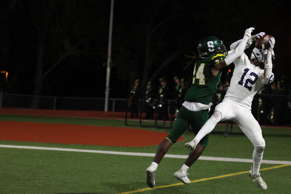 With his opponent on his side, junior Blake Jay catches the ball.