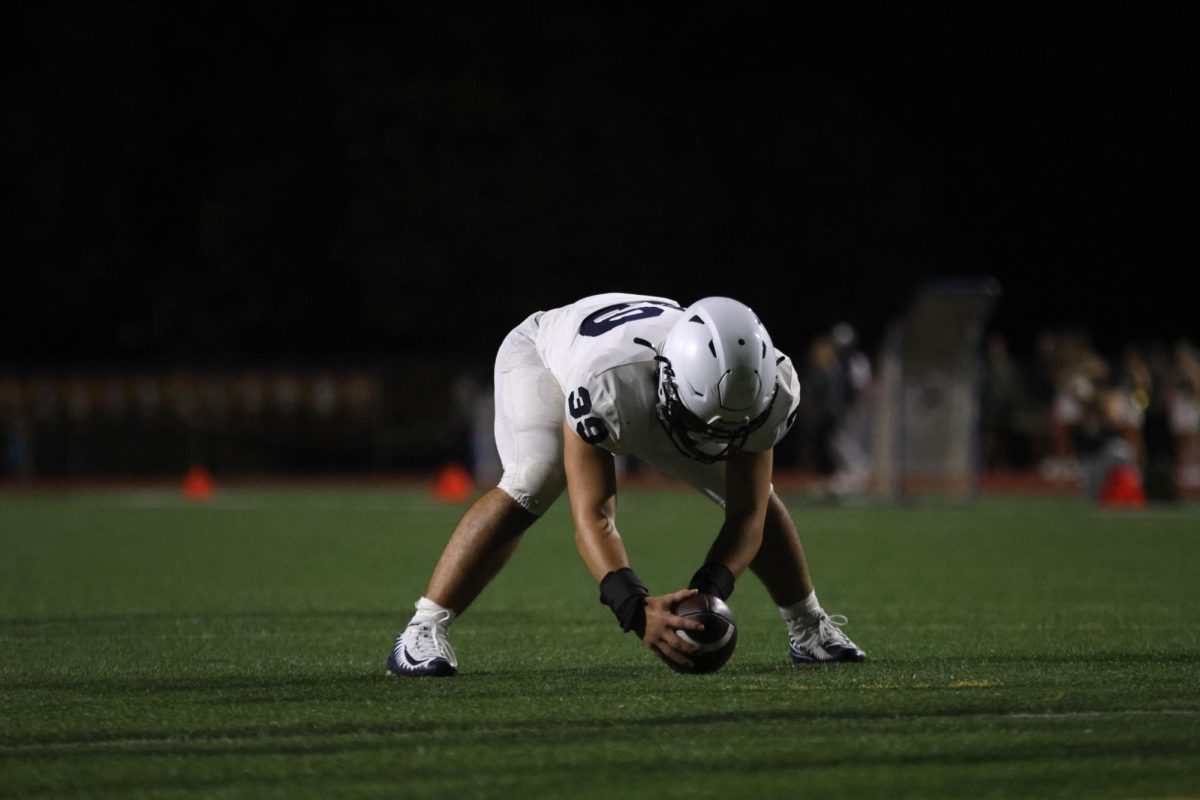 Holding the ball at his feet, sophomore Ryder Farley gets ready to snap the ball.