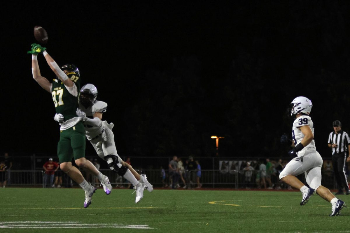 Making sure his opponent doesn't catch the ball, Senior Braden Peter holds him back.