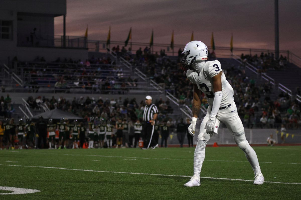 Watching his team, Senior Desmon Williams waits for the snap.