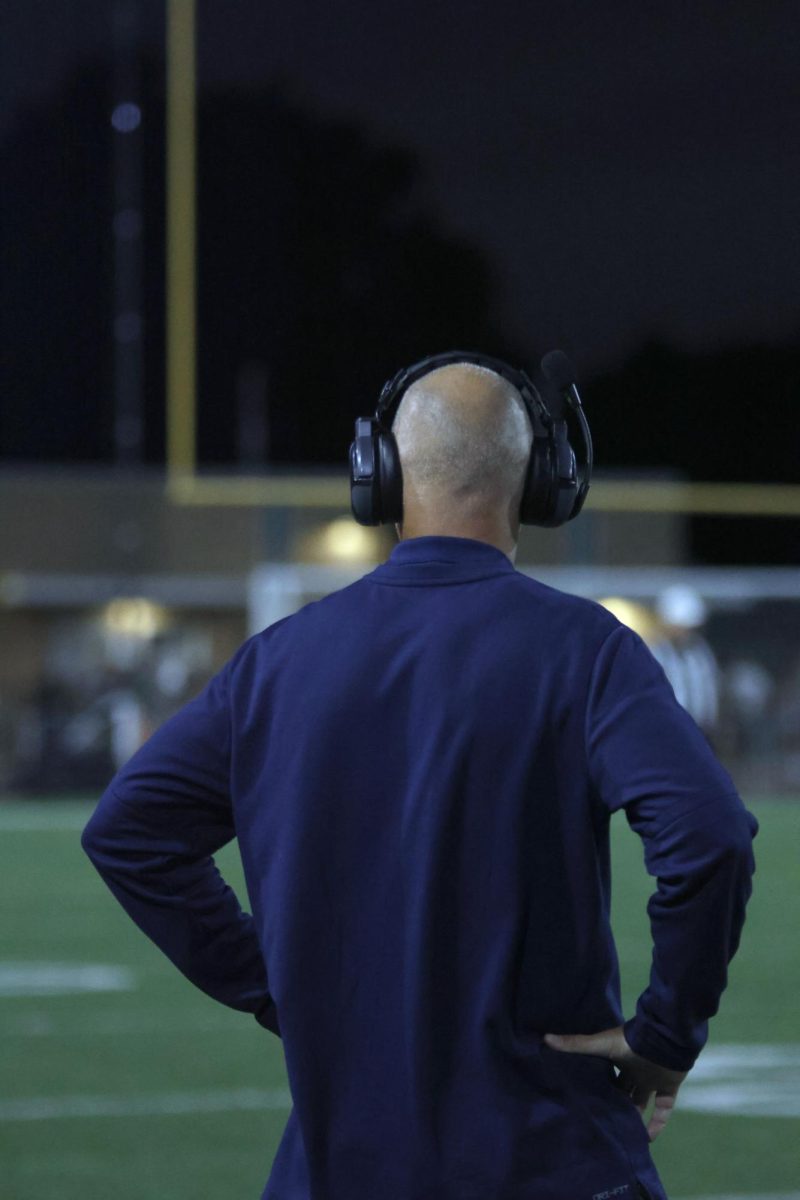 With his hands on his hips, Coach Ress watches the game.