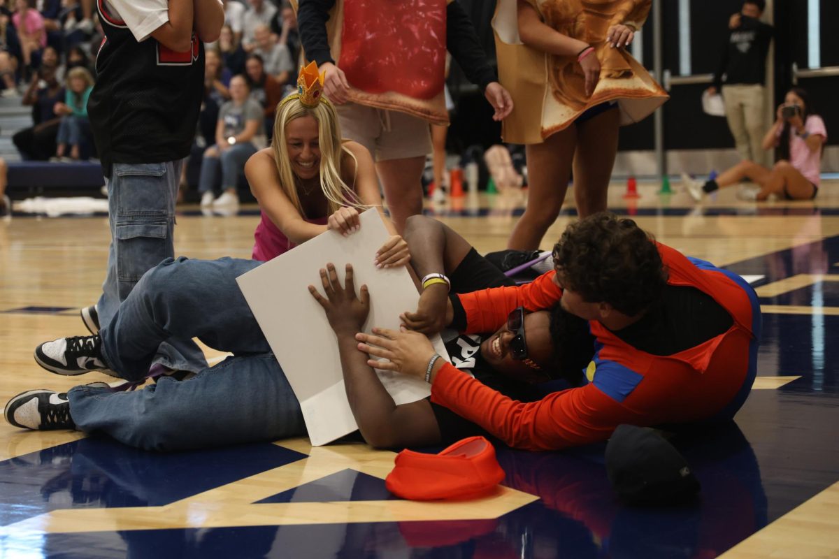 Seniors Maggie Wieland, El-Roi Hasabu and Abe Shaffer fight over a song poster during the HoCo candidate game.